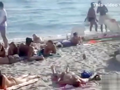 Doing the fellatio on a crowded beach