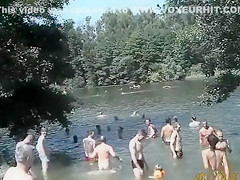 Nudist camp at the lake with lots of men and women