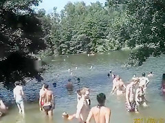 Nudist camp at the lake with lots of men and women