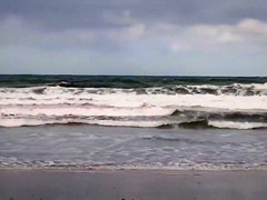 Hundreds of nudist people running into the sea naked