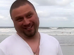 Hundreds of nudist people running into the sea naked