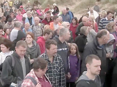 Hundreds of nudist people running into the sea naked