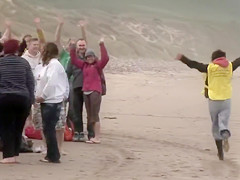 Hundreds of nudist people running into the sea naked