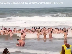 Hundreds of nudist people running into the sea naked