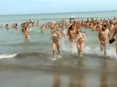 Huge group of nudists swim in the ocean