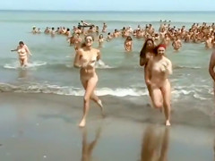 Huge group of nudists swim in the ocean
