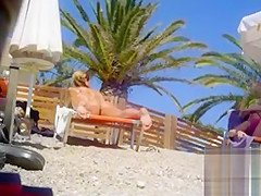 Tanned blonde takes off her bikini after a swim