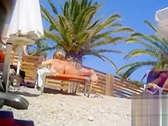 Tanned blonde takes off her bikini after a swim