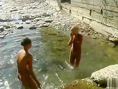 Nude teen beauties splash in the river