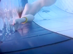 Naked women underwater at a nudist resort pool