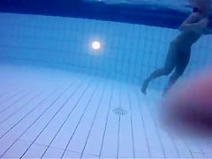 Naked women underwater at a nudist resort pool