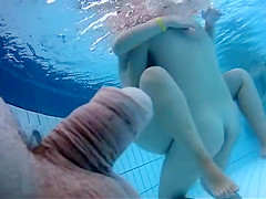 Naked women underwater at a nudist resort pool
