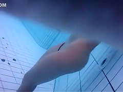 Naked women underwater at a nudist resort pool