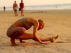 Bald beauty doing yoga by the sea