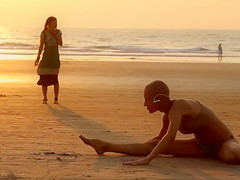 Bald beauty doing yoga by the sea