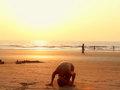 Bald beauty doing yoga by the sea