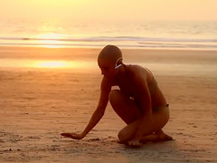 Bald beauty doing yoga by the sea