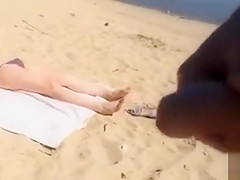 Jerking off as a bikini woman lies on the beach