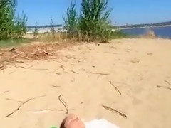 Jerking off as a bikini woman lies on the beach