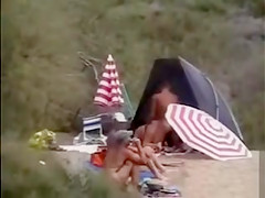 Mature nudists copulating for an audience on the nude beach