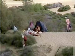 Mature nudists copulating for an audience on the nude beach