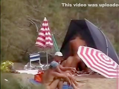 Mature nudists copulating for an audience on the nude beach