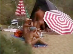 Mature nudists copulating for an audience on the nude beach