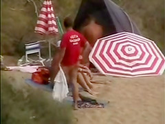 Mature nudists copulating for an audience on the nude beach