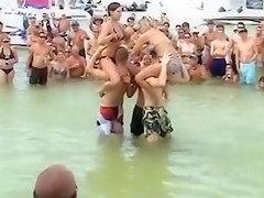 Sexy beach girls fighting each other from the shoulders of their boyfriends