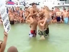 Sexy beach girls fighting each other from the shoulders of their boyfriends
