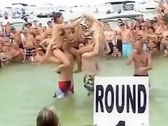 Sexy beach girls fighting each other from the shoulders of their boyfriends