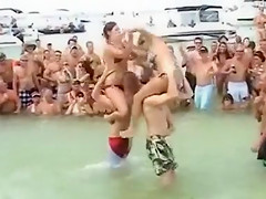 Sexy beach girls fighting each other from the shoulders of their boyfriends