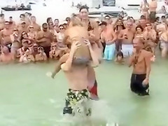 Sexy beach girls fighting each other from the shoulders of their boyfriends