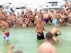 Sexy beach girls fighting each other from the shoulders of their boyfriends