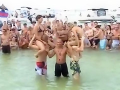 Sexy beach girls fighting each other from the shoulders of their boyfriends