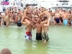 Sexy beach girls fighting each other from the shoulders of their boyfriends