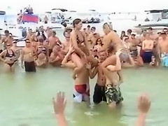 Sexy beach girls fighting each other from the shoulders of their boyfriends