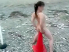 Amateur woman sits on traffic cone at the beach