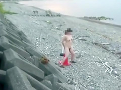 Amateur woman sits on traffic cone at the beach