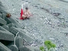 Amateur woman sits on traffic cone at the beach