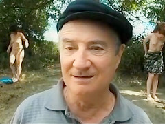 Old daddy sits with young hotties on the beach