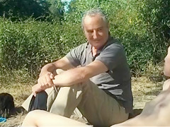 Old daddy sits with young hotties on the beach