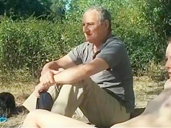 Old daddy sits with young hotties on the beach