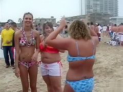 Happy girls show off their wares at a beach party