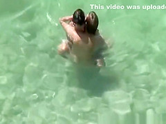 Group of nudists sunbathing in the beach