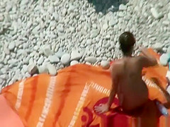 Group of nudists sunbathing in the beach