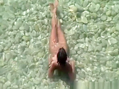 Group of nudists sunbathing in the beach