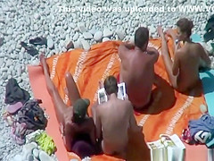 Group of nudists sunbathing in the beach