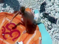 Group of nudists sunbathing in the beach