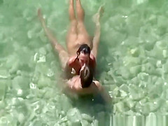 Group of nudists sunbathing in the beach